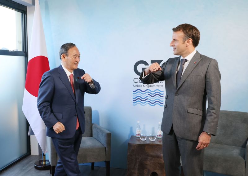 Yoshihide Suga and Emmanuel Macron greet each other, G7